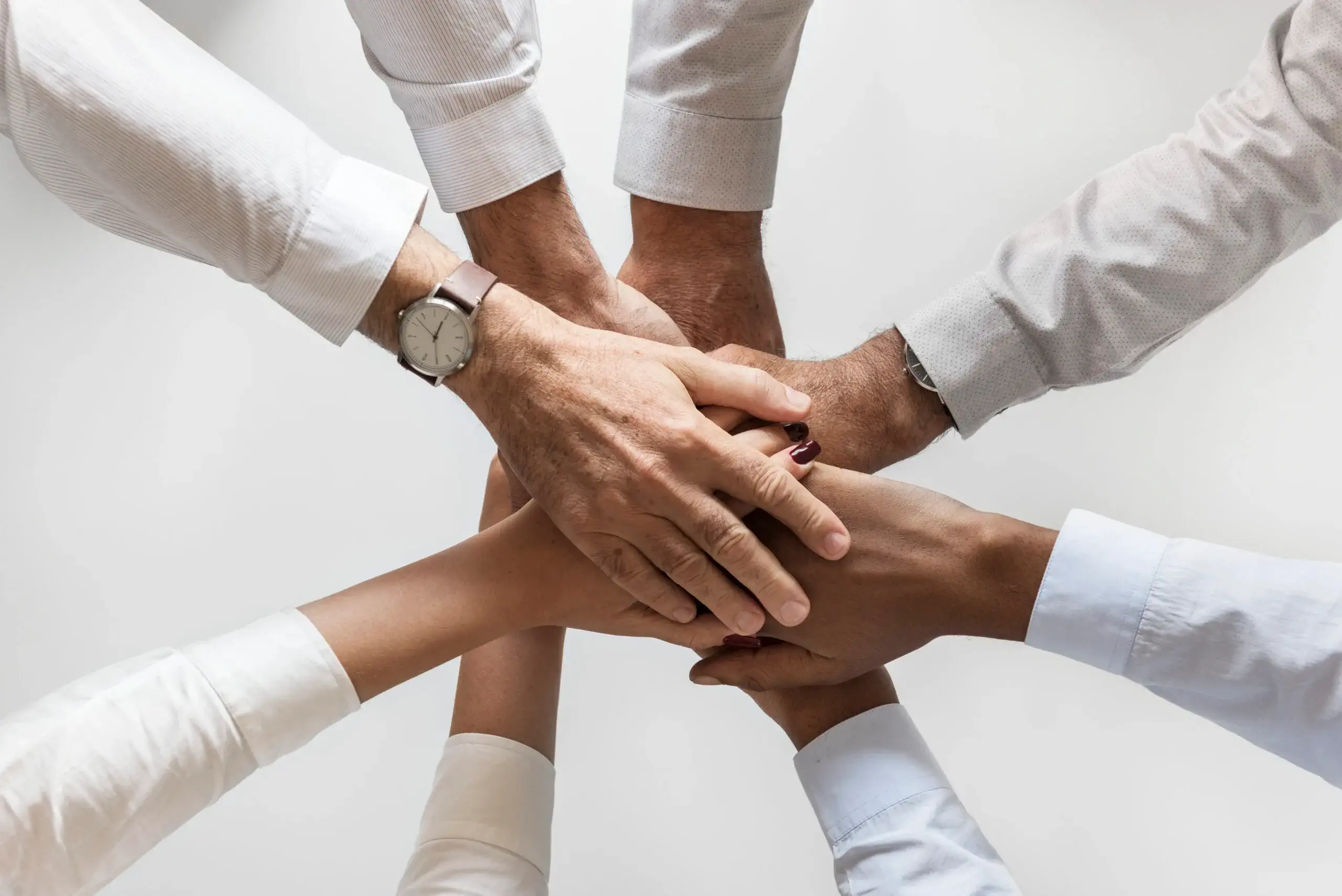 business-hands-joined-together-teamwork-scaled (1)
